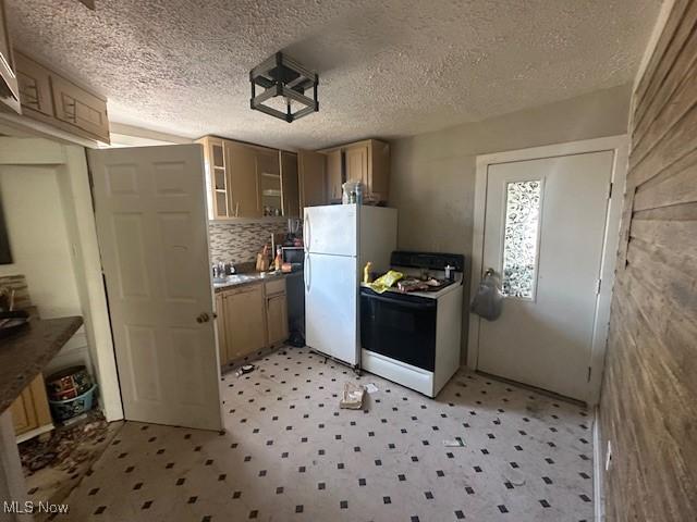 kitchen with range with gas cooktop, glass insert cabinets, light floors, and freestanding refrigerator