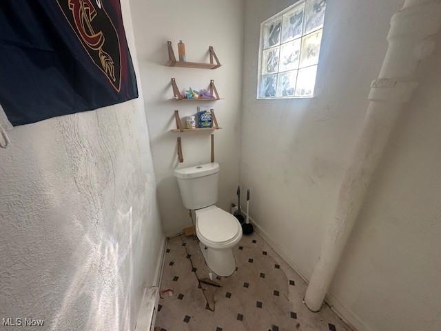 bathroom featuring baseboard heating and toilet