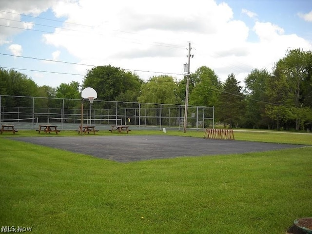 exterior space featuring basketball hoop and a lawn