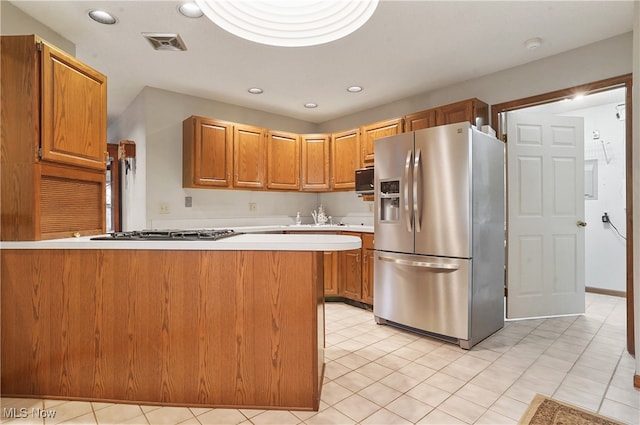 kitchen featuring kitchen peninsula, stainless steel appliances, and light tile patterned flooring