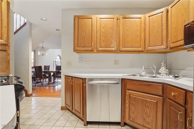6747 Lockwood Blvd, Youngstown, OH 44512 - kitchen with stainless steel appliances, a sink, light tile patterned floors, light countertops, and a chandelier