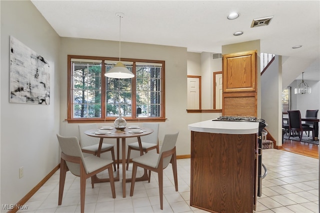 tiled dining room featuring an inviting chandelier