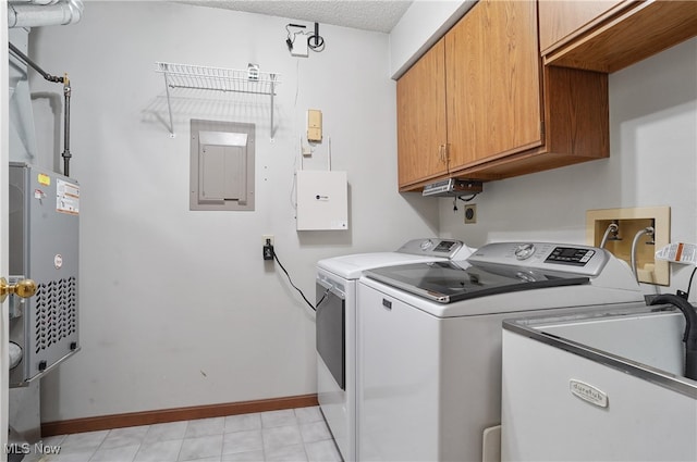 clothes washing area with electric panel, cabinets, a textured ceiling, sink, and washing machine and clothes dryer