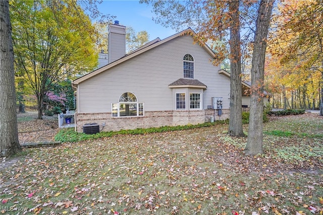 6747 Lockwood Blvd, Youngstown, OH 44512 - view of home's exterior with brick siding, a chimney, and central AC unit