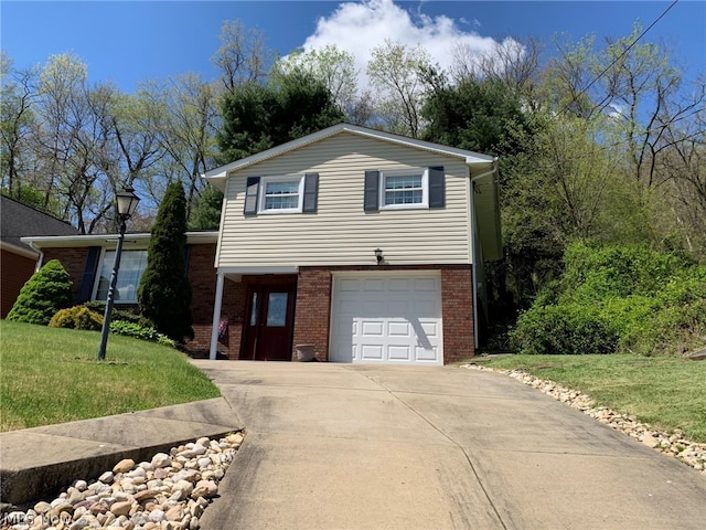 split level home featuring an attached garage, a front lawn, concrete driveway, and brick siding