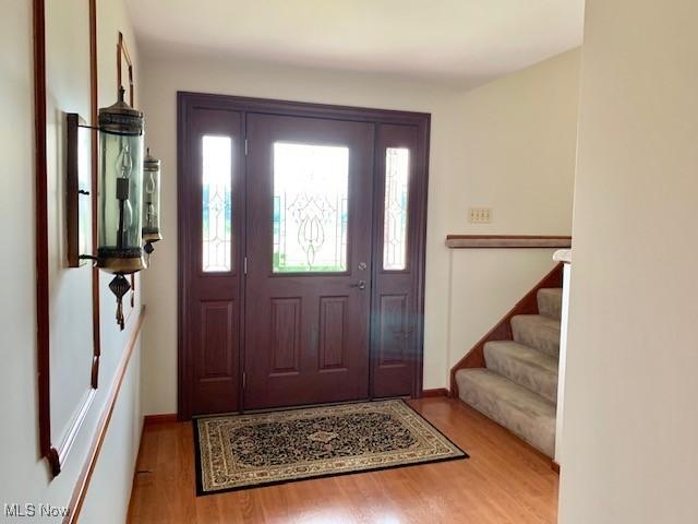 foyer featuring baseboards and wood finished floors