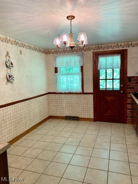 interior space with a notable chandelier and light tile patterned flooring