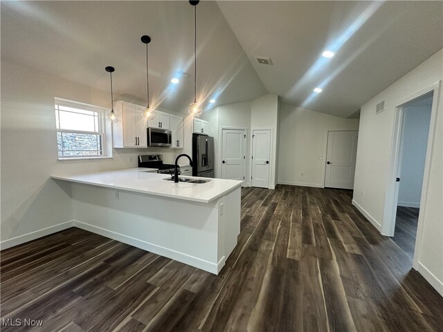 kitchen featuring kitchen peninsula, white cabinets, appliances with stainless steel finishes, vaulted ceiling, and dark hardwood / wood-style floors