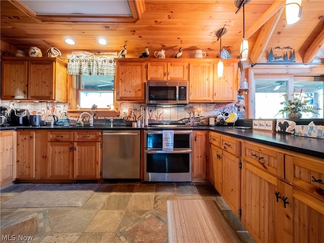 kitchen with backsplash, stainless steel appliances, light tile floors, and hanging light fixtures