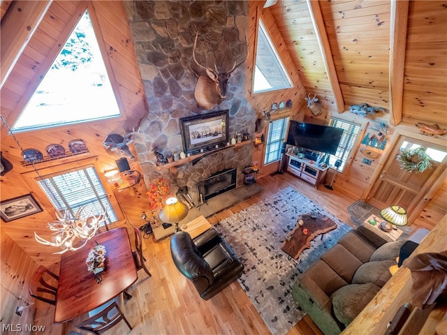 living room with wood-type flooring, a fireplace, wooden ceiling, and beamed ceiling