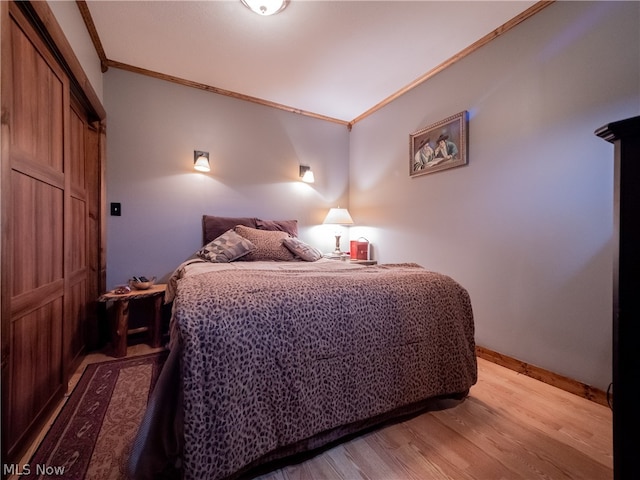 bedroom featuring light hardwood / wood-style flooring and crown molding