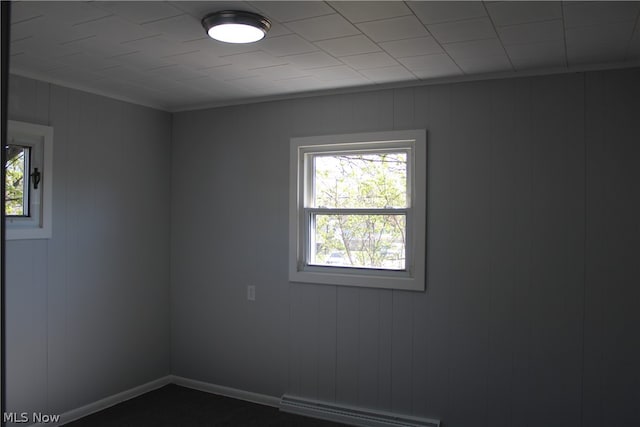 empty room with carpet and a baseboard heating unit