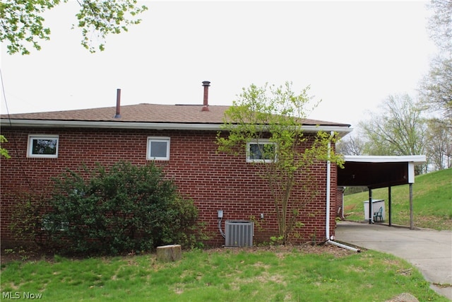 view of side of home featuring central AC unit and a carport