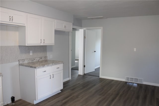 kitchen featuring white cabinets and dark wood-type flooring