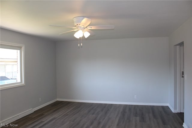 empty room with dark hardwood / wood-style floors, a baseboard radiator, and ceiling fan