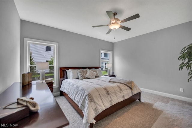 carpeted bedroom with multiple windows and ceiling fan