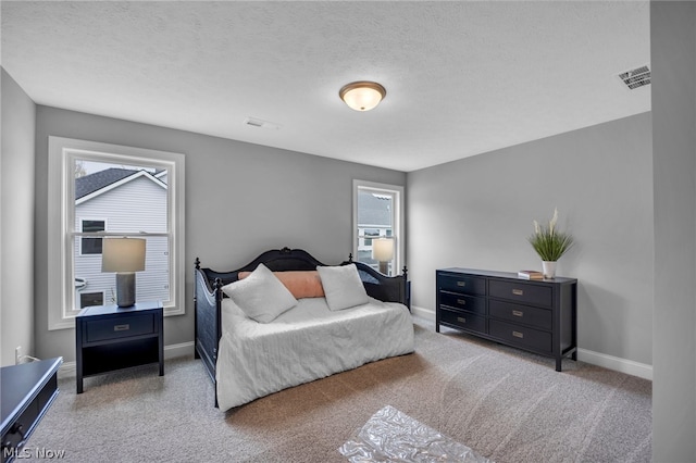 bedroom featuring carpet flooring, a textured ceiling, and multiple windows