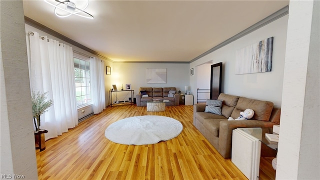 living room featuring light wood-type flooring and crown molding