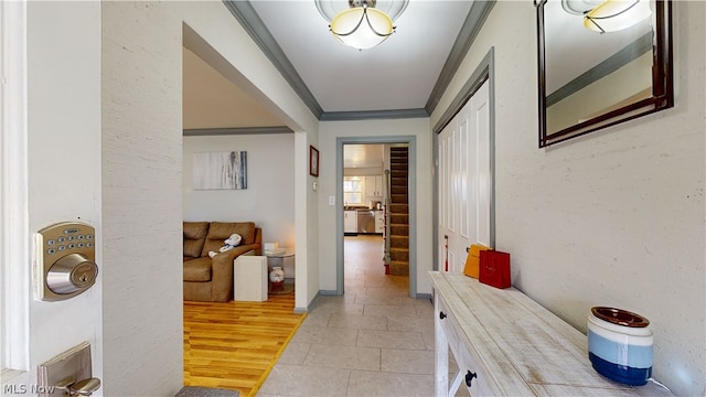 hall with ornamental molding and light hardwood / wood-style flooring