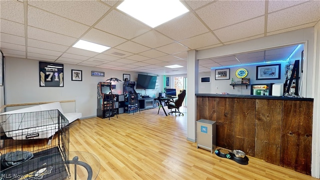 interior space featuring wood-type flooring and a drop ceiling