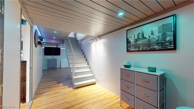 staircase featuring wooden ceiling and hardwood / wood-style flooring