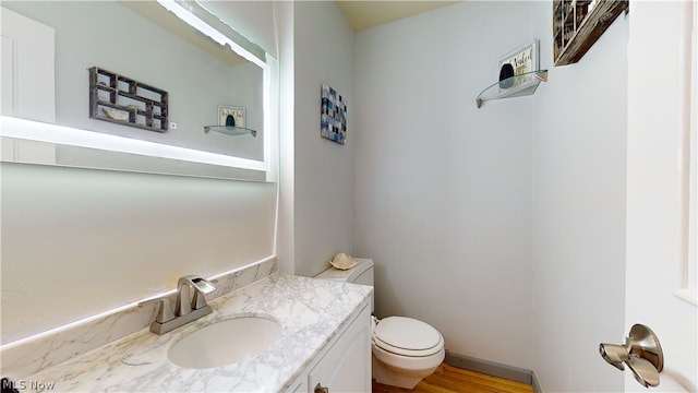 bathroom with vanity, toilet, and hardwood / wood-style flooring