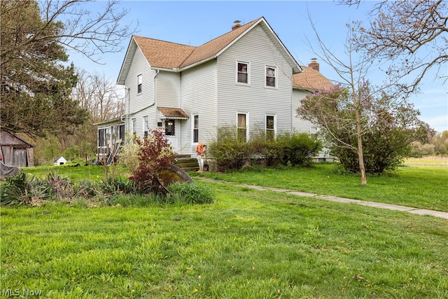 back of house with a lawn