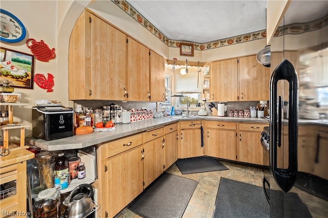 kitchen featuring fridge, sink, backsplash, light tile flooring, and hanging light fixtures