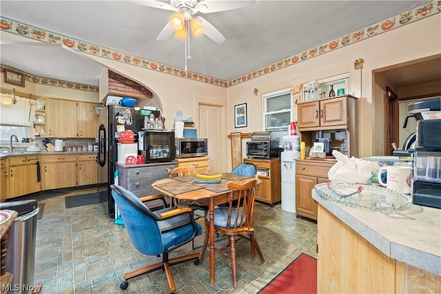 dining area with dark tile flooring, ceiling fan, and sink