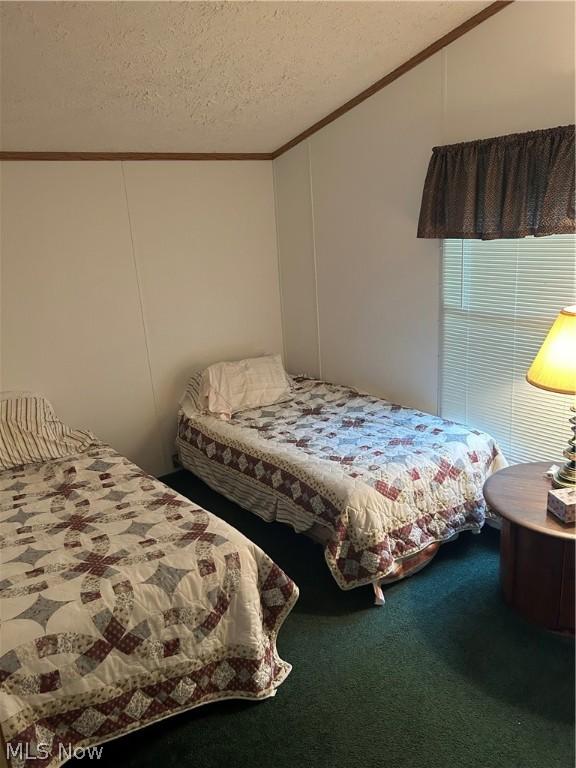 bedroom featuring ornamental molding, vaulted ceiling, carpet floors, and a textured ceiling