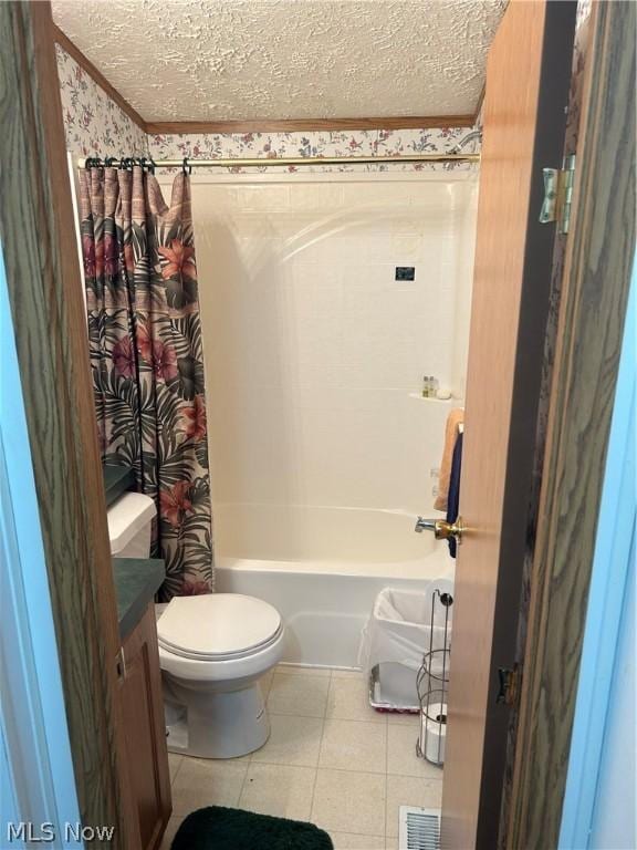 full bathroom with tile patterned flooring, shower / tub combo with curtain, a textured ceiling, and toilet