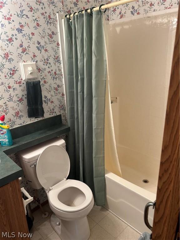 full bathroom featuring shower / tub combo with curtain, tile patterned floors, toilet, and vanity