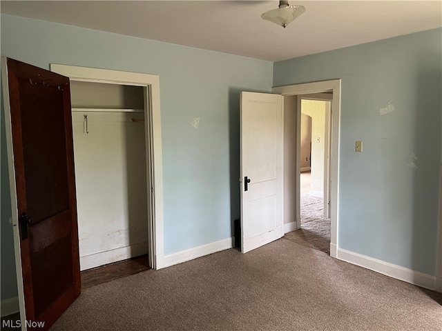 unfurnished bedroom featuring a closet and dark carpet