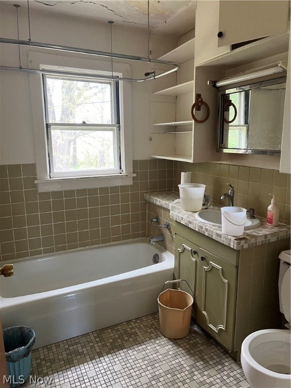 full bathroom featuring backsplash, toilet, vanity, and  shower combination