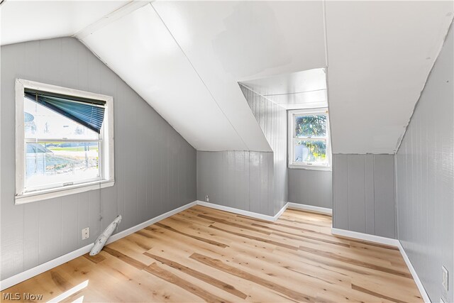 bonus room featuring lofted ceiling and light hardwood / wood-style flooring