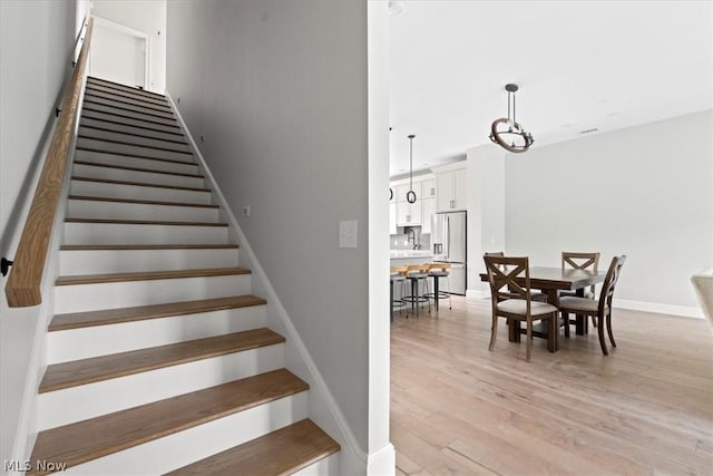 stairs with wood-type flooring and sink