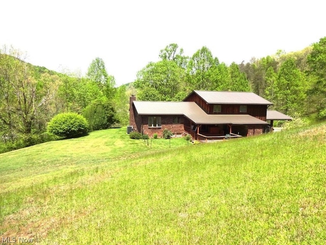 11421 Clay Rd, Newton, WV 25266 - rear view of house featuring a lawn, a chimney, and a forest view
