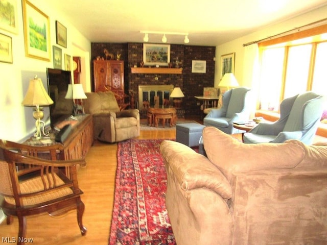 11421 Clay Rd, Newton, WV 25266 - living area featuring a brick fireplace and wood finished floors