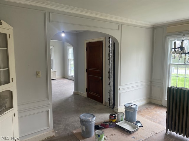 interior space with a wealth of natural light, radiator, and crown molding