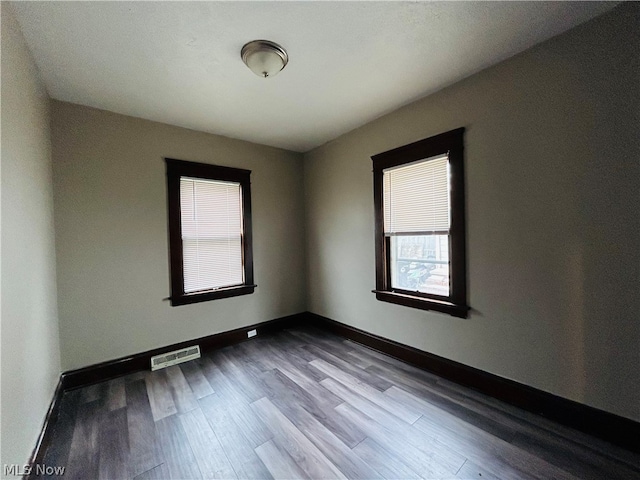 unfurnished room featuring dark wood-type flooring