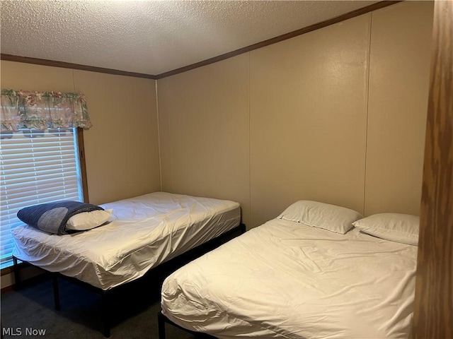 carpeted bedroom with a textured ceiling and ornamental molding