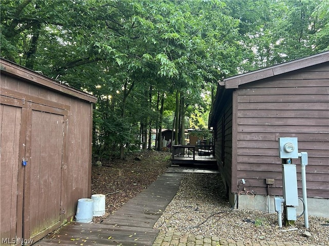 view of yard featuring a wooden deck and a storage shed