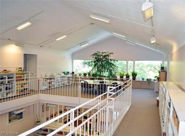 hall featuring vaulted ceiling and carpet floors