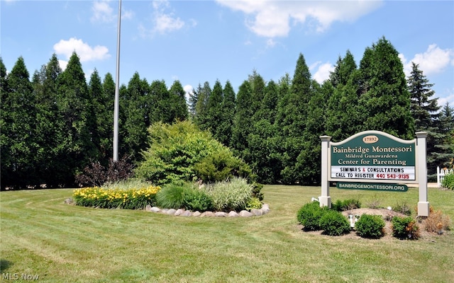 community / neighborhood sign featuring a yard