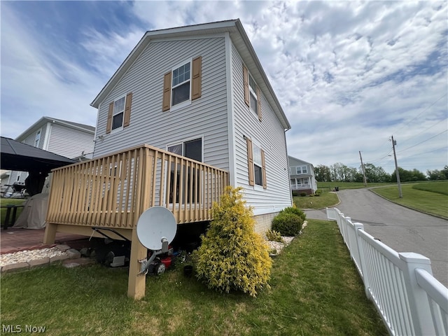 rear view of property with a deck and a lawn