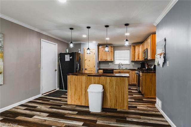 kitchen with hanging light fixtures, sink, dark wood-type flooring, and black appliances