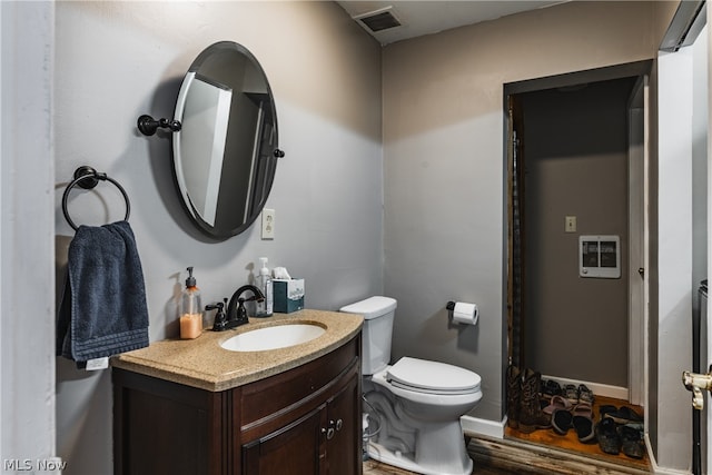 bathroom featuring wood-type flooring, vanity, and toilet