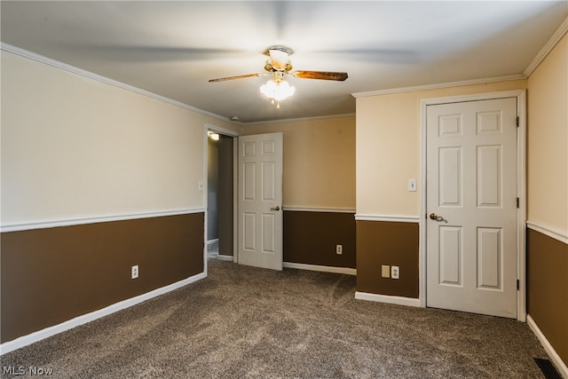 unfurnished room featuring dark colored carpet, ceiling fan, and ornamental molding