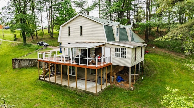 rear view of house featuring a patio area, a deck, central AC unit, and a lawn