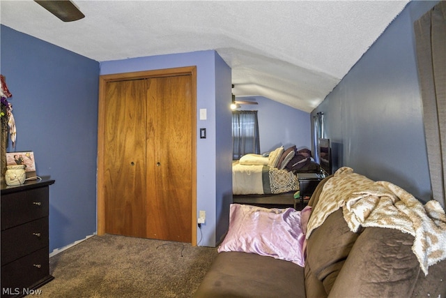 bedroom with a closet, ceiling fan, a textured ceiling, lofted ceiling, and carpet floors